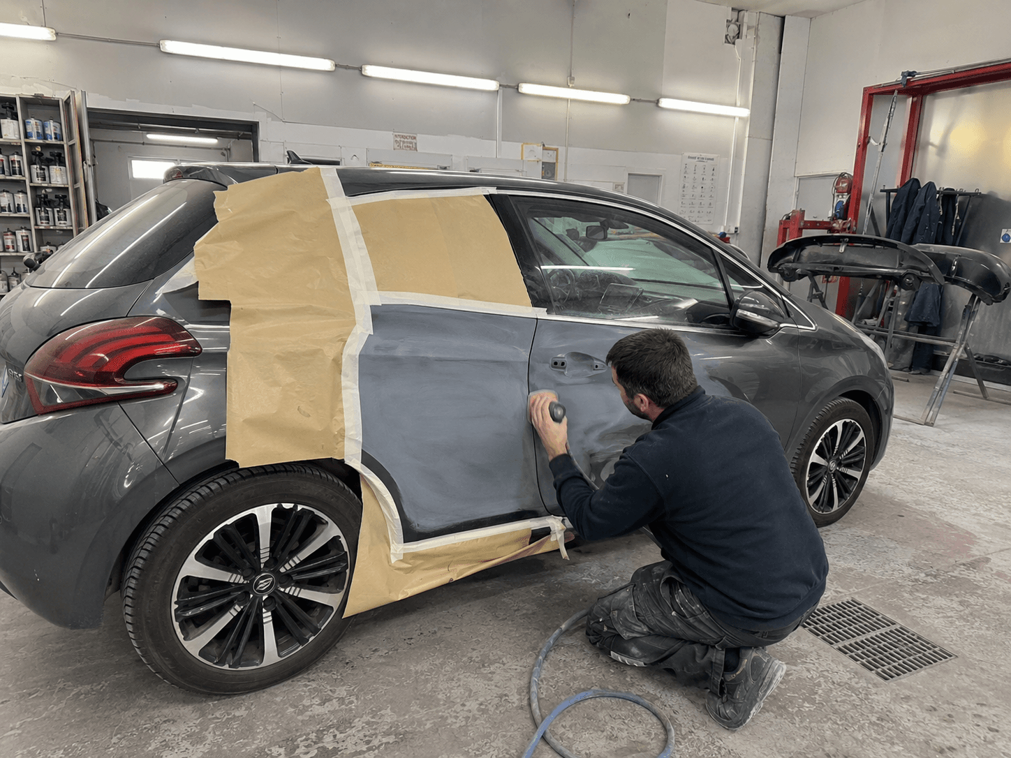 Réparation de carrosserie sur une Peugeot dans l'atelier